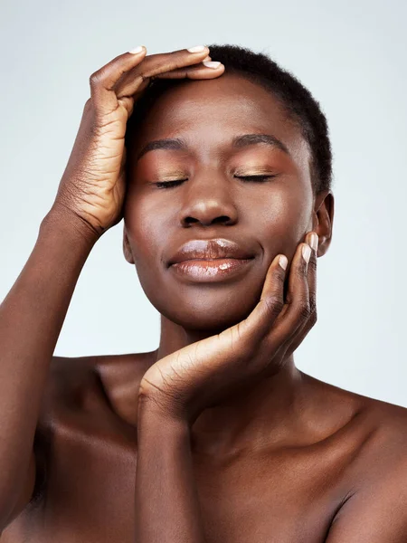 Achteruit en kijk hoe ze gloeit. Studio shot van een mooie jonge vrouw voelt haar huid tegen een grijze achtergrond. — Stockfoto