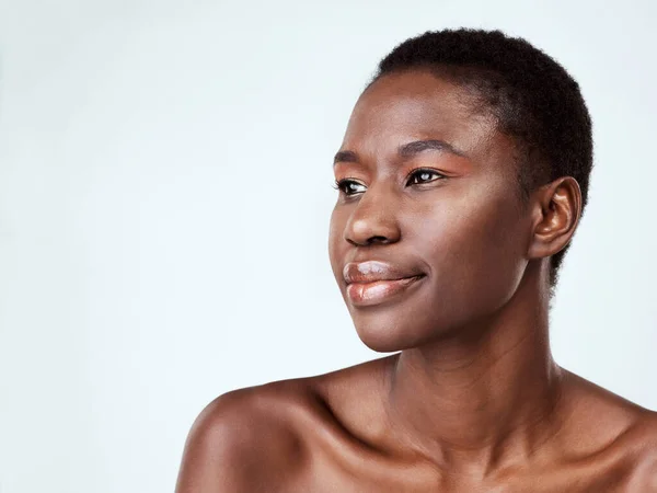 Elle prouve qu'une peau parfaite est possible. Plan studio d'une belle jeune femme à la recherche réfléchie sur un fond gris. — Photo