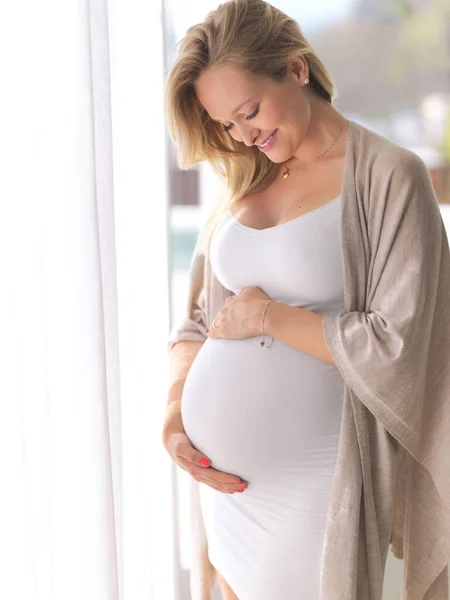 Widać, jakie to ekscytujące. Ujęcie pięknej, młodej kobiety w ciąży stojącej w swoim domu. — Zdjęcie stockowe