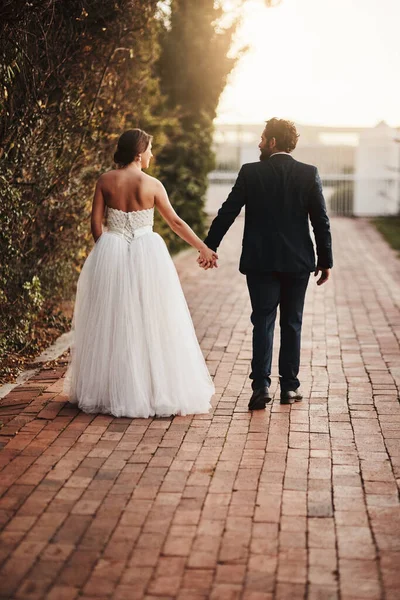 Puede ser siempre caminar por la vida juntos. Vista trasera de una pareja caminando juntos en el día de su boda. —  Fotos de Stock