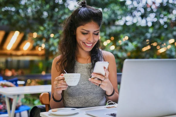 Im in diesem coolen Café mit dem besten Kaffee. Aufnahme einer jungen Frau mit Handy und Laptop in einem Café. — Stockfoto