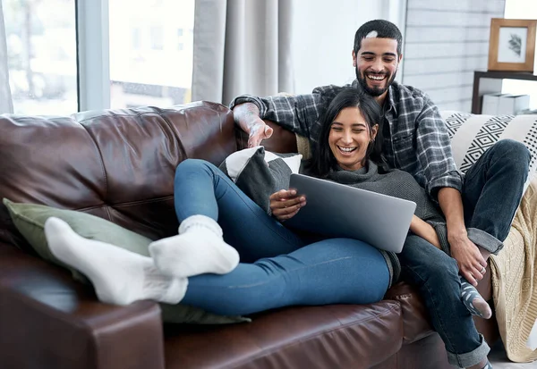 Romance nem sempre é um encontro chique em um restaurante. Tiro de um jovem casal usando um laptop enquanto relaxa no sofá em casa. — Fotografia de Stock