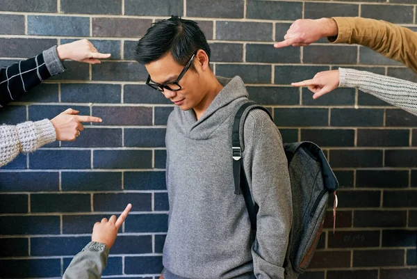 Bullying is a serious issue. Cropped shot of a young male university student being bullied while standing in a campus corridor. — Stock Photo, Image