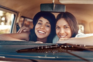 The best bonding experience. A road trip. Shot of two happy young friends going on a road trip. clipart