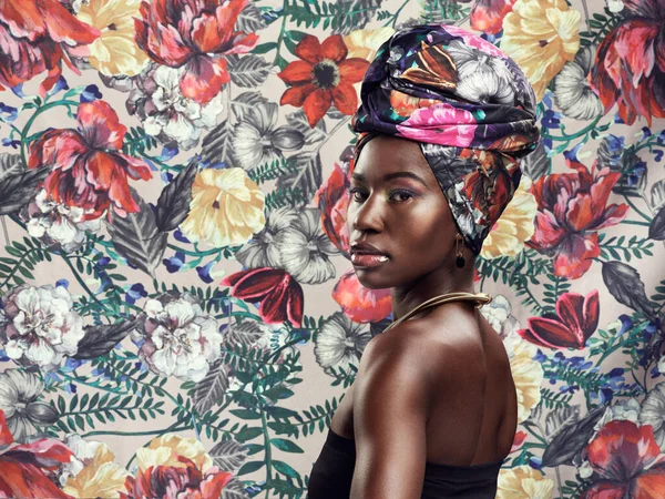 그냥 전하라고 부르 세요. 스튜디오에서는 아름다운 젊은 여자가 꽃으로 뒤덮인 배경에 전통적 인 아프리카 머리덮개를 쓰고 있는 장면을 촬영하였다. — 스톡 사진