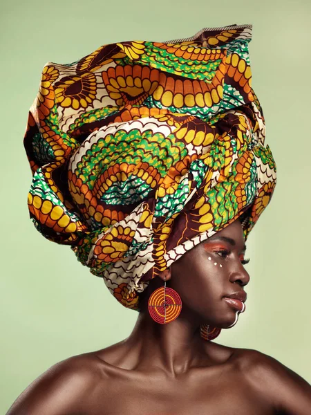 La vie est meilleure en couleur. Plan studio d'une belle jeune femme portant un foulard africain traditionnel sur fond vert. — Photo