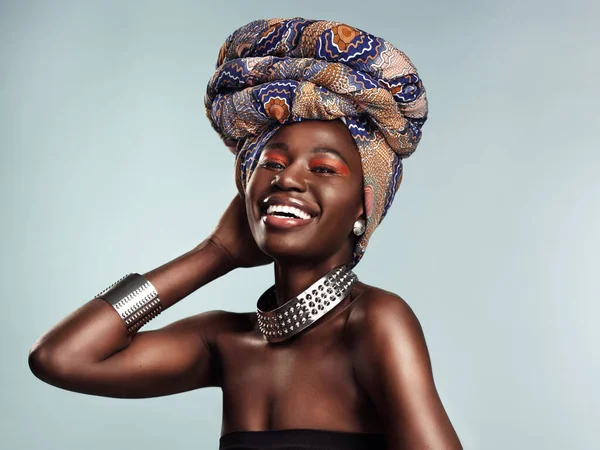 Nic tak nie dopełnia twojego wyglądu jak stylowa okładka na głowę. Studio ujęcie pięknej młodej kobiety w tradycyjnej afrykańskiej okładce na szarym tle. — Zdjęcie stockowe