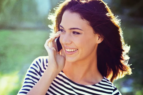 Het perfecte moment om te kletsen. Foto van een prachtige jonge vrouw aan de telefoon terwijl buiten. — Stockfoto