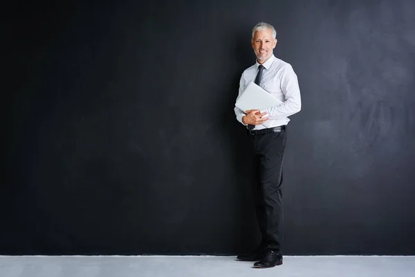 Ich habe Ihre Firma abgesichert. Studioporträt eines gestandenen Geschäftsmannes vor schwarzem Hintergrund. — Stockfoto