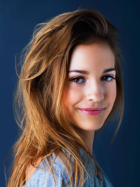 Ze heeft een makkelijke geest. Studio portret van een schattig tienermeisje glimlachen en poseren tegen een donkere achtergrond. — Stockfoto