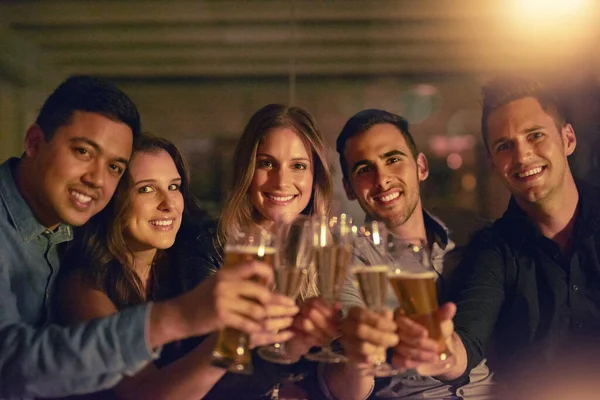 Hay que celebrar la vida. Retrato de un grupo de personas brindando con sus bebidas en un club nocturno. — Foto de Stock