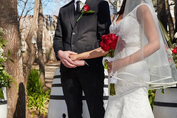 Den stora dagen är äntligen här. Beskuren bild av en brud och brudgum vid deras utomhus bröllop ceremoni. — Stockfoto