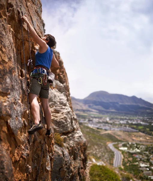 Alpinista corajoso. Tiro de uma jovem mulher cortando em um parafuso enquanto escalada. — Fotografia de Stock