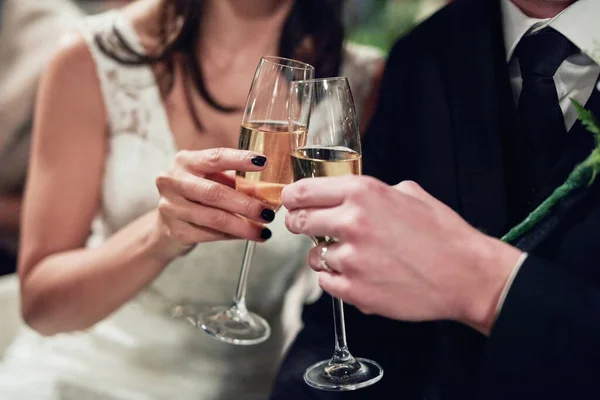 Het delen van de eerste toast als Mr en Mrs Cropped shot van een pasgetrouwd stel toosten met wijn op hun trouwdag. — Stockfoto