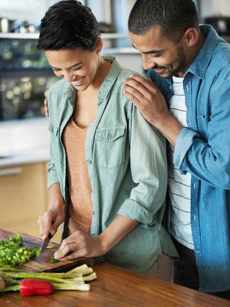 Já está delicioso. Tiro de um jovem casal afetuoso preparando uma refeição juntos em sua cozinha. — Fotografia de Stock