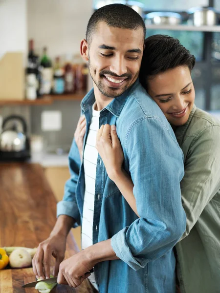 Todos os chefes precisam de um pouco de amor. Tiro de um jovem casal afetuoso preparando uma refeição juntos em sua cozinha. — Fotografia de Stock