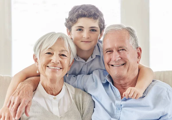 Hij houdt ons jong. shot van een volwassen paar bonding met hun kleinzoon op de bank thuis. — Stockfoto
