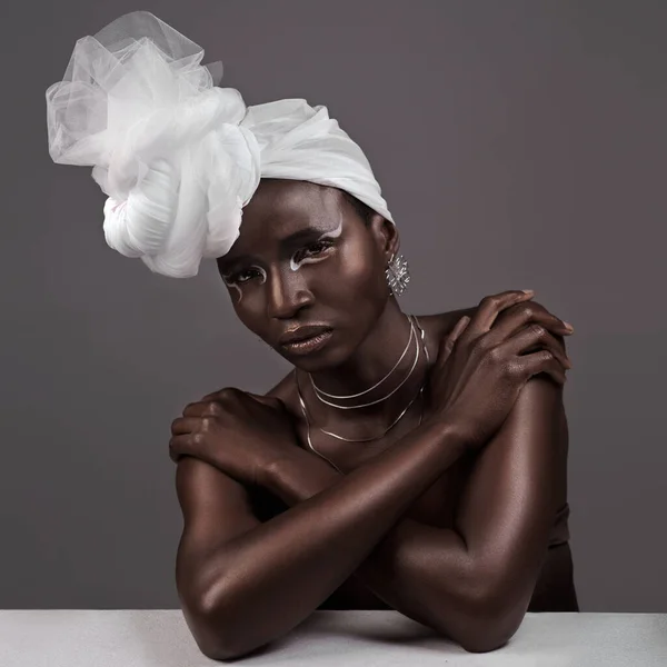 La beauté indéniable d'une enveloppe de tête. Portrait en studio d'une jolie jeune femme posant en tenue traditionnelle africaine sur fond gris. — Photo