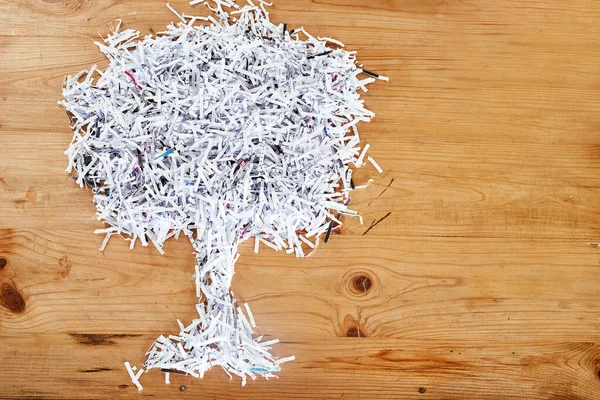 Salve o ambiente. Reciclar. Estúdio tiro de papel desfiado dispostos na forma de uma árvore em uma mesa de madeira. — Fotografia de Stock