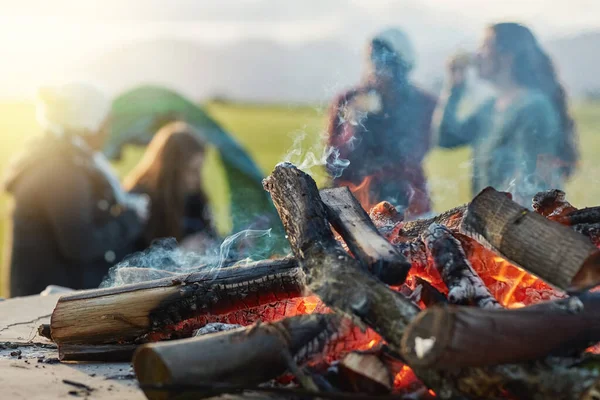 Das Schmieden starker Bindungen am Feuer. Aufnahme einer Gruppe junger Freunde beim Kaffee am Feuer während eines Campingausflugs. — Stockfoto