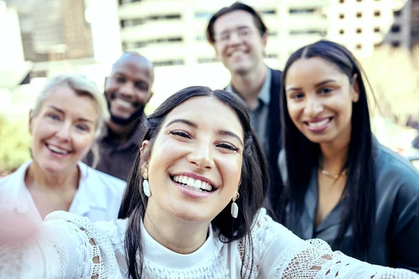 Encuentro que cuanto más trabajamos, más tenemos. Fotografía de un grupo de colegas de negocios tomando selfies fuera. —  Fotos de Stock