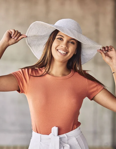 Im working on a world premier. Portrait of an attractive young woman wearing a sunhat posing against an urban background. — Stock Photo, Image