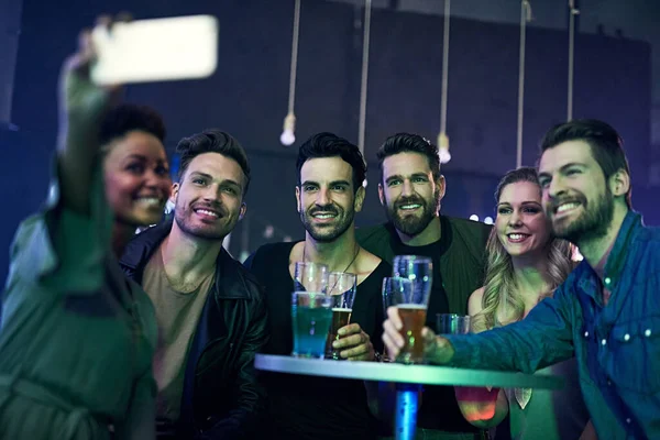 Recordando una noche increíble. Fotografía de un grupo de jóvenes amigos tomando una selfie juntos mientras festejan en un club nocturno. — Foto de Stock