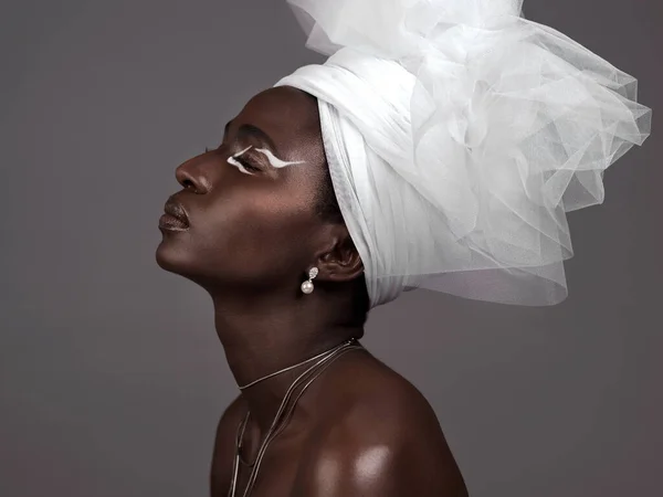 Ze belichaamt Afrikaanse schoonheid. Studio shot van een aantrekkelijke jonge vrouw poseren in traditionele Afrikaanse kleding tegen een grijze achtergrond. — Stockfoto