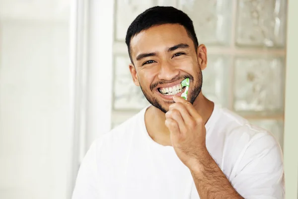 Esta es la mejor pasta de dientes, la prueba está en mi sonrisa. El disparo de un joven guapo cepillándose los dientes en casa. — Foto de Stock