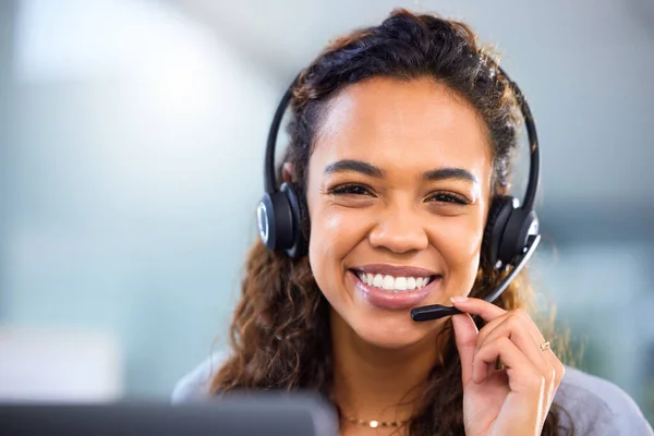 Blij u van dienst te zijn. Gesneden portret van een aantrekkelijke jonge vrouwelijke call center agent werken aan haar bureau in het kantoor. — Stockfoto