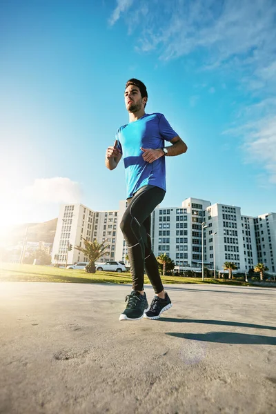 Correr es increíblemente beneficioso para el cuerpo y la mente. Tiro de un joven deportivo para salir a correr. — Foto de Stock