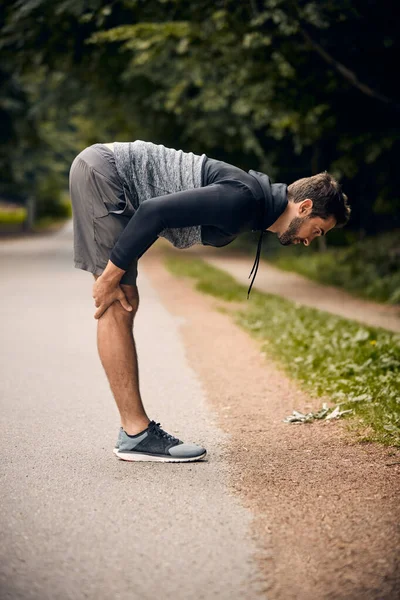 Ζεσταίνομαι πριν το τρέξιμο. Shot of a sporty man starting his άσκηση ρουτίνας με ασκήσεις τεντώματος. — Φωτογραφία Αρχείου