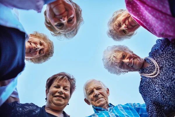 Att åldras graciöst tillsammans. Låg vinkel skott av en grupp seniorer utanför. — Stockfoto