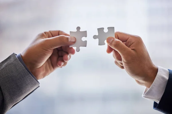 Beh, trovate una soluzione insieme. Colpo ritagliato di due uomini d'affari che tengono insieme pezzi di puzzle. — Foto Stock