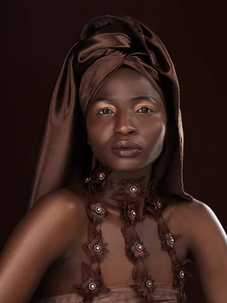 Alguns dizem cabeça embrulhada, eu digo coroa. Estúdio retrato de uma jovem atraente posando em traje tradicional Africano contra um fundo preto. — Fotografia de Stock