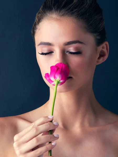A veces las cosas más simples también son hermosas. Estudio de una atractiva joven posando y oliendo una hermosa rosa rosa. — Foto de Stock
