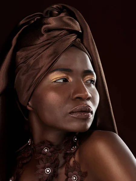 Elle se secoue la tête. Plan studio d'une jolie jeune femme posant en tenue traditionnelle africaine sur fond noir. — Photo