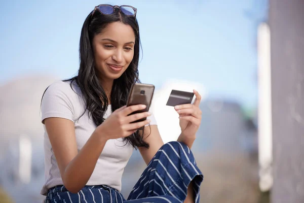 Les prêts étudiants sont implacables. Tourné d'une belle jeune étudiante utilisant son téléphone tout en étant assise à l'extérieur. — Photo