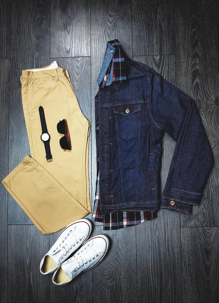 Acessórios para combinar com a roupa. Tiro de ângulo alto de uma roupa casual em uma roupa de madeira. — Fotografia de Stock
