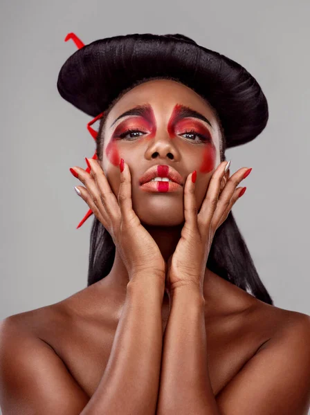 A queen is a queen wherever you come from. Studio shot of a beautiful young woman wearing Asian inspired makeup against a grey background. — Stock Photo, Image