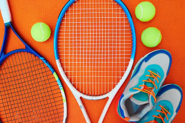 Ahora solo necesito un oponente. Tiro de alto ángulo de elementos esenciales de tenis colocados sobre un fondo naranja dentro de un estudio. —  Fotos de Stock