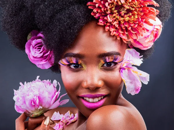 Het enige wat je moet doen is een beetje roze toevoegen. Studio shot van een mooie jonge vrouw poseren met bloemen in haar haar. — Stockfoto