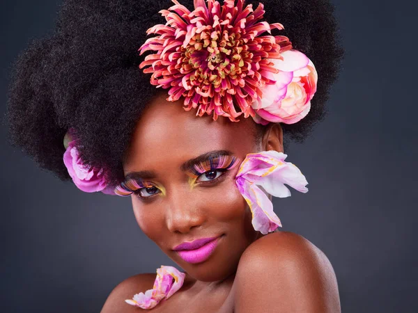 Elle a l'air fraîche et à son meilleur. Studio plan d'une belle jeune femme posant avec des fleurs dans ses cheveux. — Photo