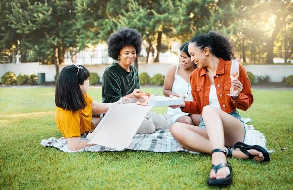Truly great friends are hard to find. Shot of a group of friends having champagne and pizza in a park. — Stock Photo, Image