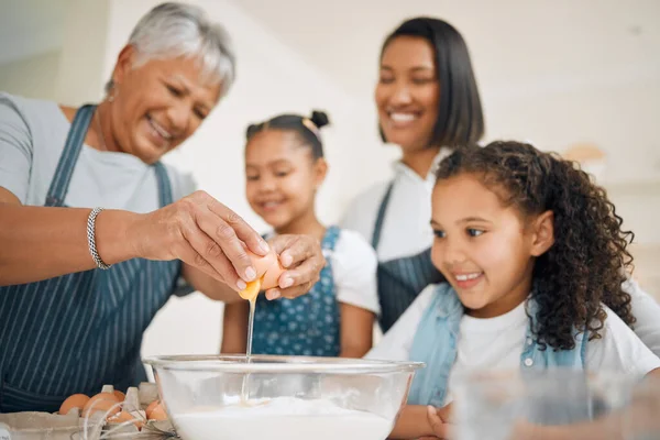 The eggs make it extra fluffy. Shot of a multi-generational family baking together at home. — Stock Photo, Image