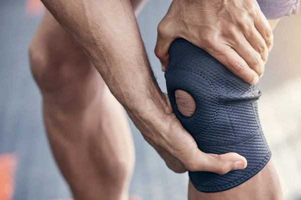 Veel stressoefeningen doen kan je knie pijn doen. Close-up shot van een onherkenbare man die zijn knie pijn doet tijdens het sporten in een sportschool. — Stockfoto