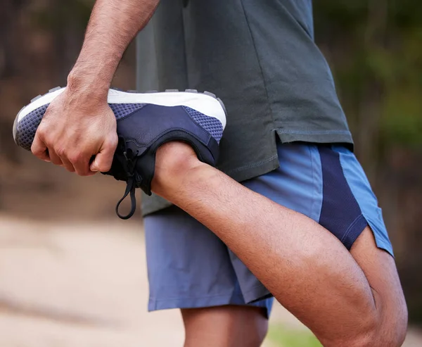 クワッドを伸ばせ。屋外で運動中に足を伸ばしている認識できない男の閉鎖ショット. — ストック写真