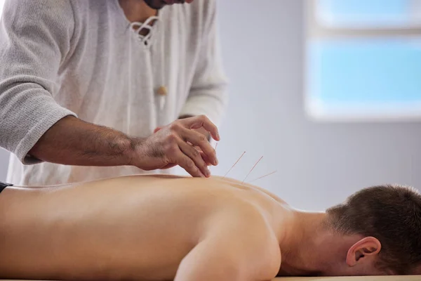 Je ne me suis jamais senti aussi détendu. Prise de vue d'un acupuncteur traitant un client. — Photo