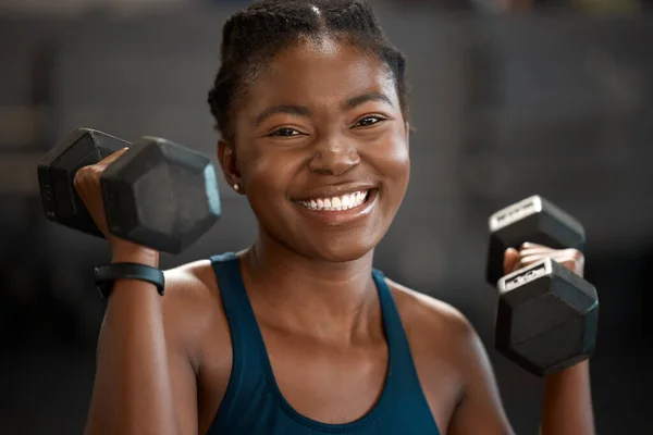Soy más feliz cuando me levanto. Retrato recortado de una joven atractiva y atlética haciendo ejercicio con pesas en el gimnasio. — Foto de Stock