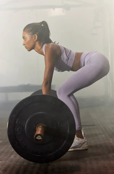 Heben Sie etwas Gewicht und ändern Sie Ihr Leben. Aufnahme einer sportlichen jungen Frau beim Hantel-Kreuzheben in einem Fitnessstudio. — Stockfoto